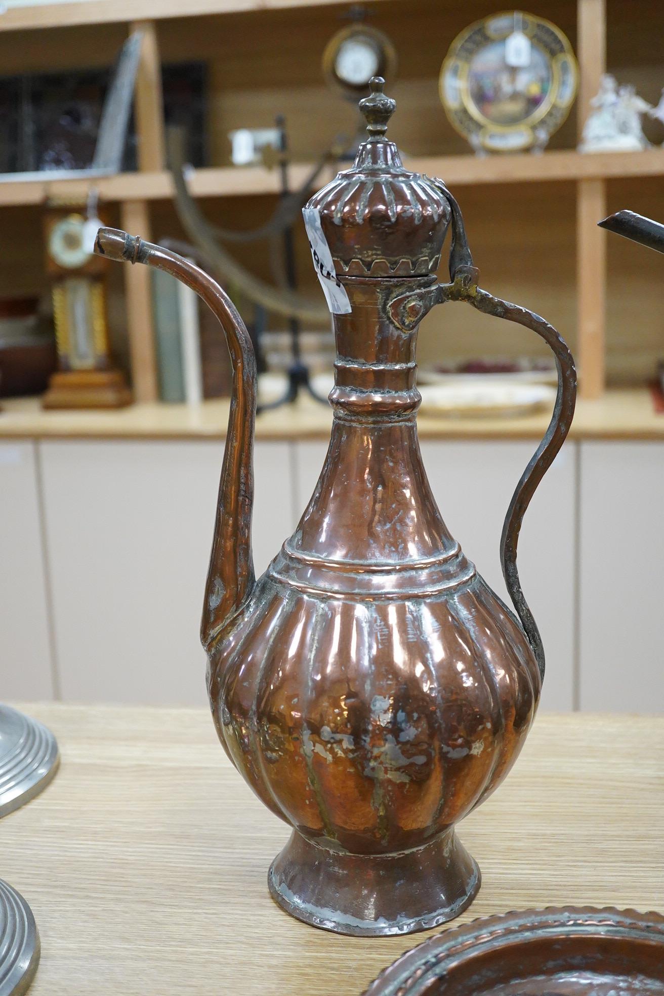 Two Middle eastern tinned copper coffee pots ‘Dallah’ a similar dish and a European copper kettle, tallest 41cm high
